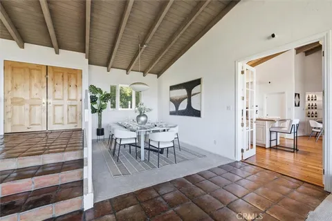 a view of a a dining room with furniture a chandelier and wooden floor