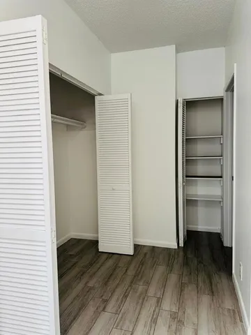 a view of walk in closet with wooden floor