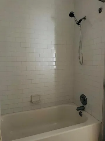 a bathroom with a bath tub with a shower