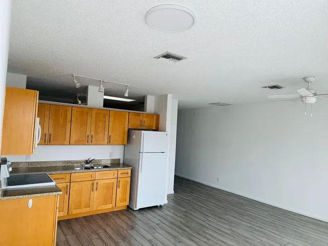 a kitchen with granite countertop wooden floors and a white cabinets