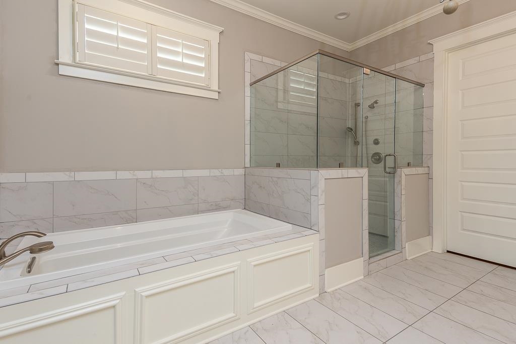 328 Washington Street Collierville, TN 38017 - Photo 15 of 33 Soaking tub with white paneled surround, glass-enclosed shower, white tile flooring, and a window with plantation shutters