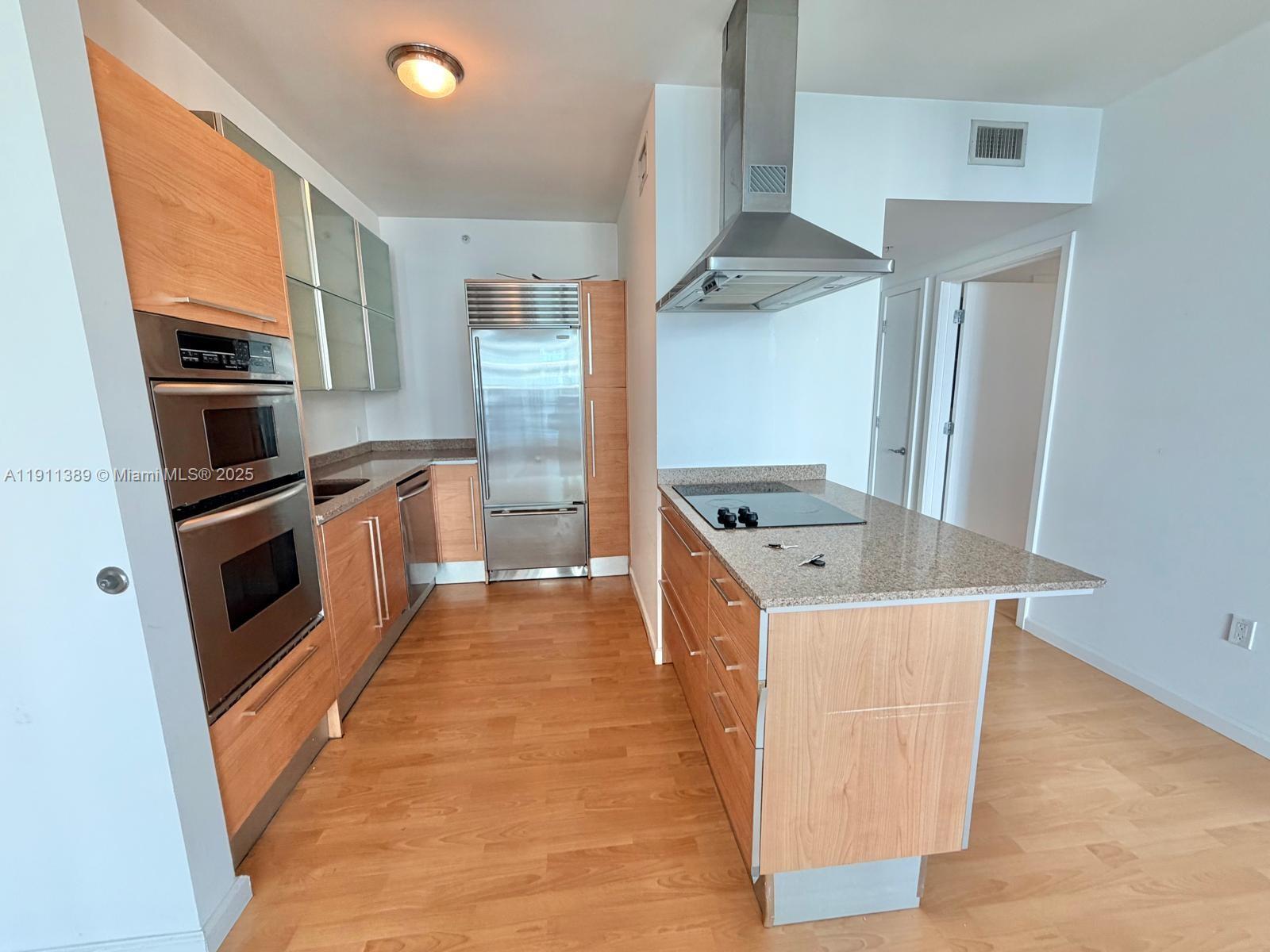 218 Southeast 14th Street, Unit 2102 Miami, FL 33131 - Photo 2 of 19 a kitchen with stainless steel appliances granite countertop a refrigerator a stove and a sink