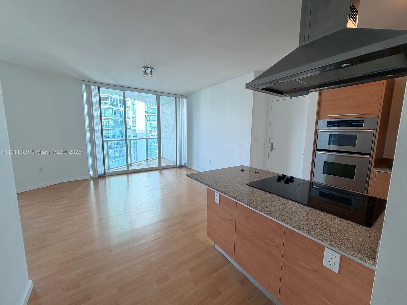 218 Southeast 14th Street, Unit 2102 Miami, FL 33131 - Photo 4 of 19 a kitchen with stainless steel appliances granite countertop a sink and a microwave