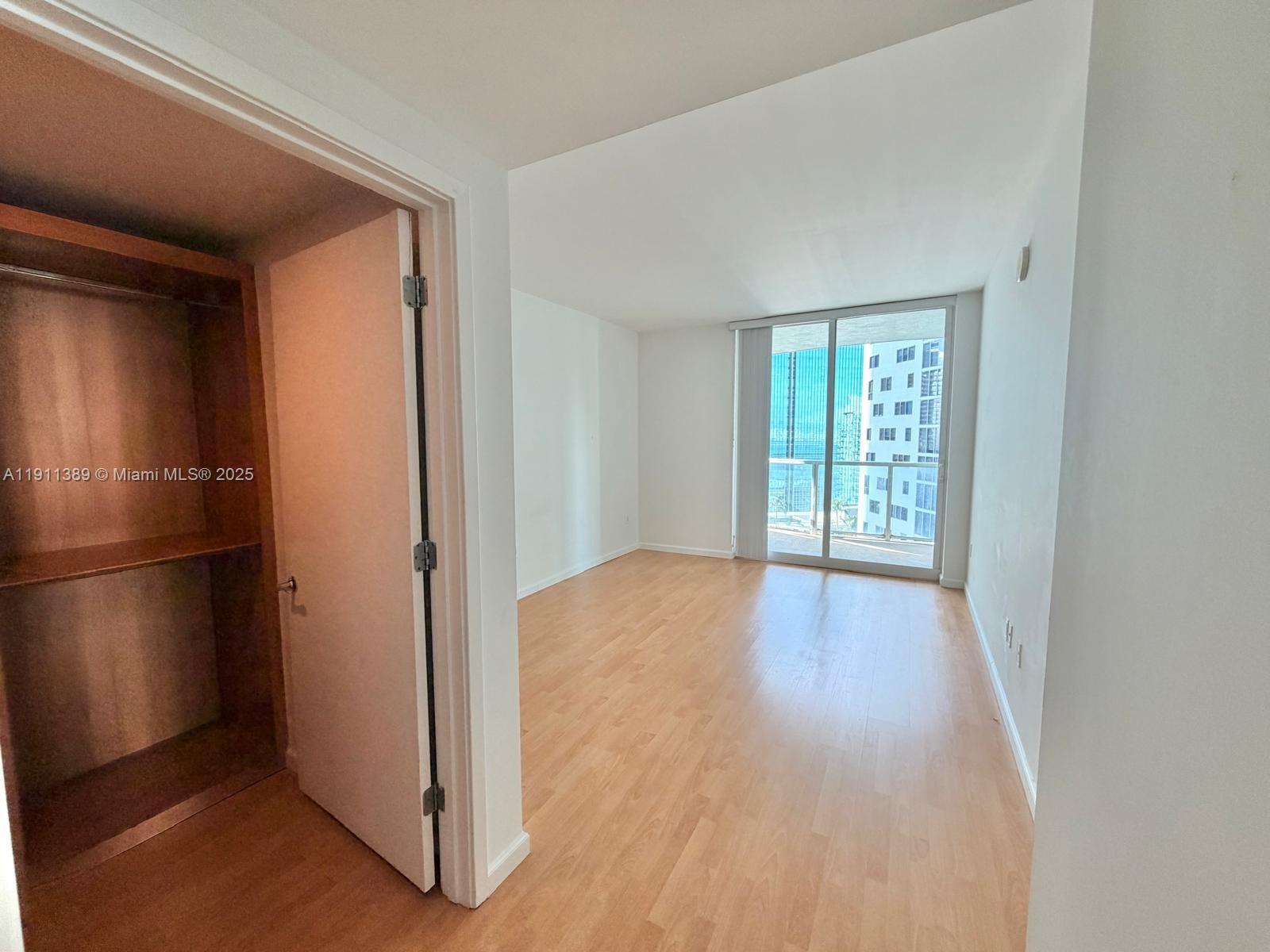 218 Southeast 14th Street, Unit 2102 Miami, FL 33131 - Photo 7 of 19 a view of an empty room with wooden floor and a window