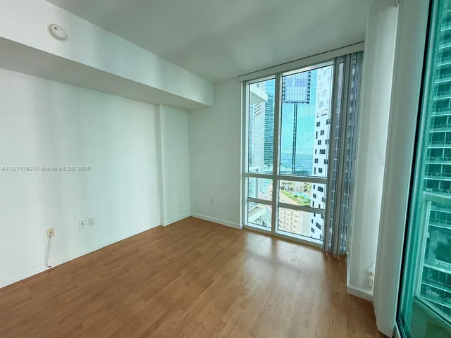 a view of an empty room with glass door and a window