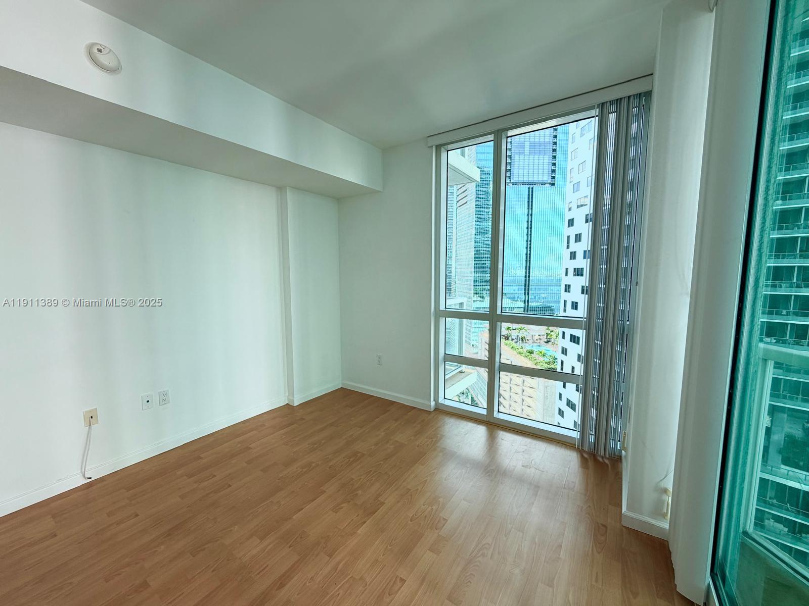 218 Southeast 14th Street, Unit 2102 Miami, FL 33131 - Photo 8 of 19 a view of an empty room with glass door and a window