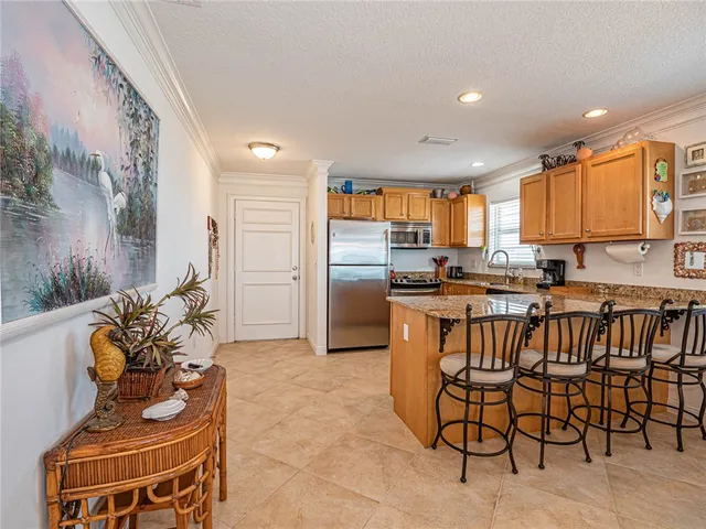 a kitchen with stainless steel appliances kitchen island granite countertop a refrigerator and microwave