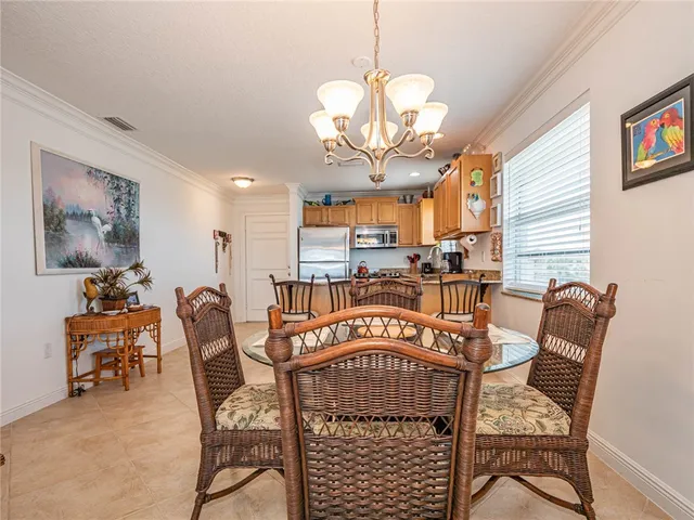 a view of a dining room with furniture a chandelier and wooden floor