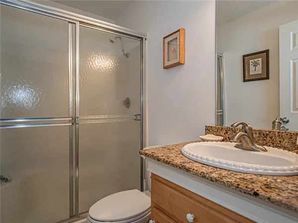 a bathroom with a granite countertop sink toilet and shower