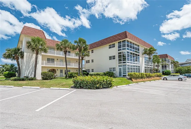 a front view of a house with a yard and potted plants