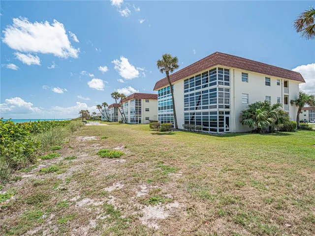 a view of a house with a yard and potted plants