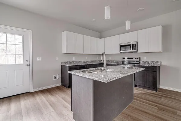 a kitchen with stainless steel appliances granite countertop a sink stove and microwave