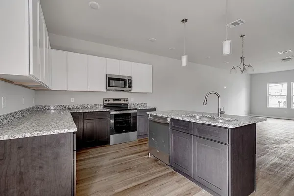 a kitchen with stainless steel appliances granite countertop a sink stove and cabinets
