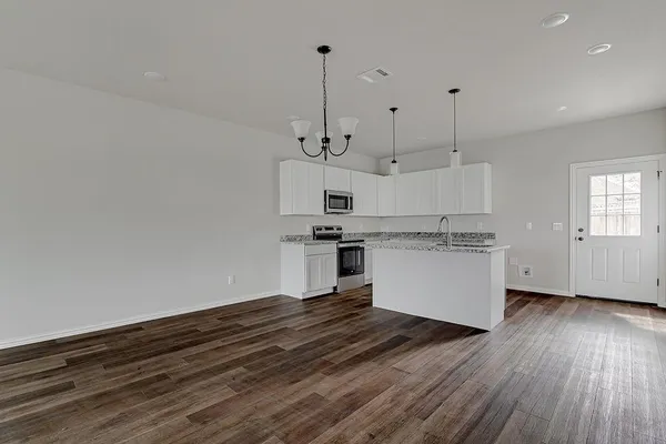 a view of kitchen with granite countertop cabinets and wooden floor