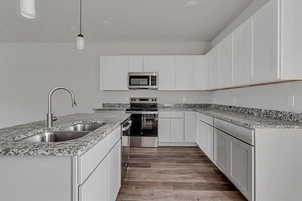 a kitchen with granite countertop a sink and cabinets
