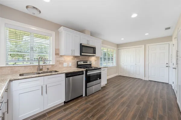 a kitchen with a sink stove and microwave