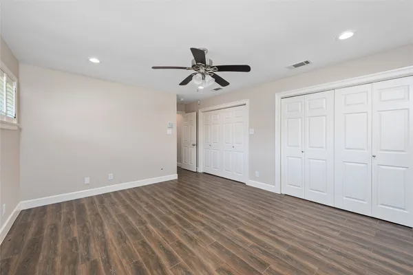 a view of a room with wooden floor and a ceiling fan