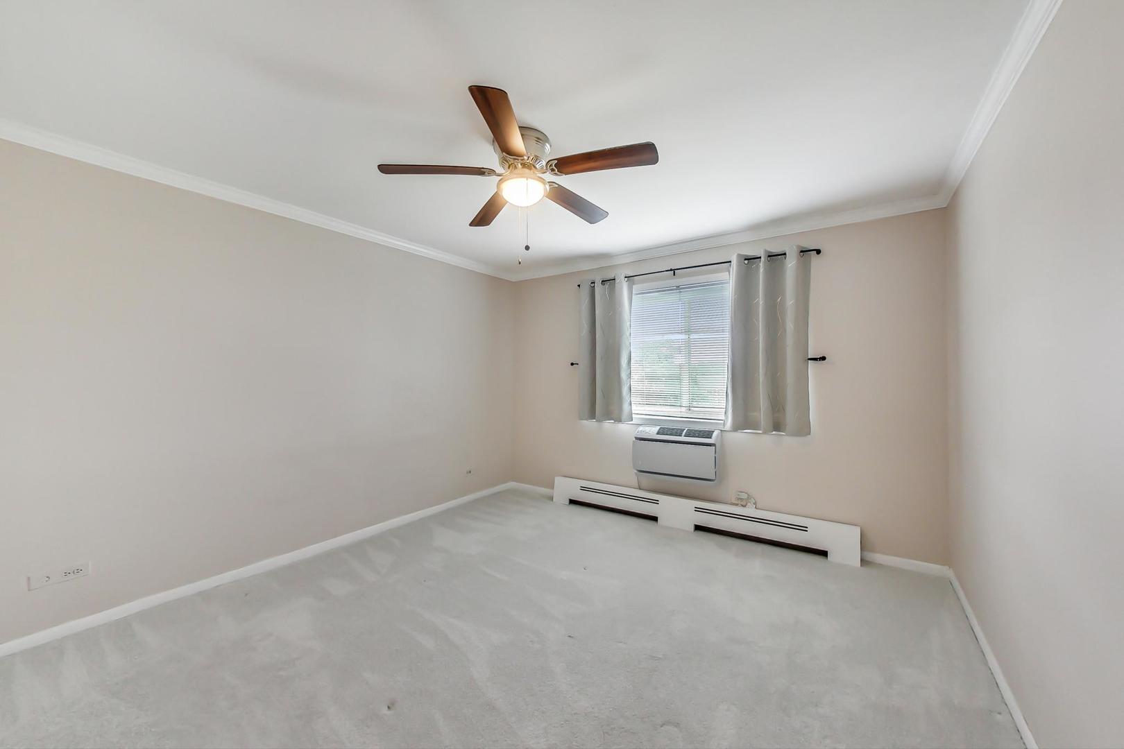 2234 South Goebbert Road, Unit 425 Arlington Heights, IL 60005 - Photo 10 of 20 an empty room with windows and ceiling fan