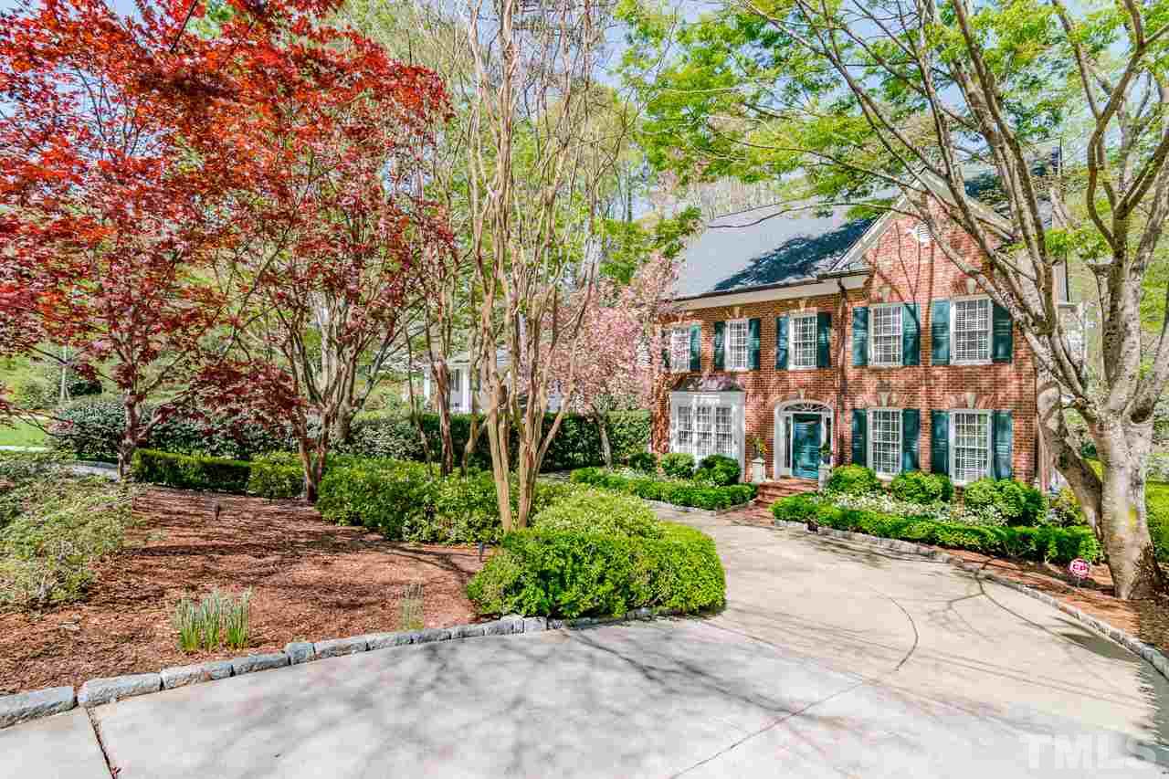 a front view of a house with a yard and trees