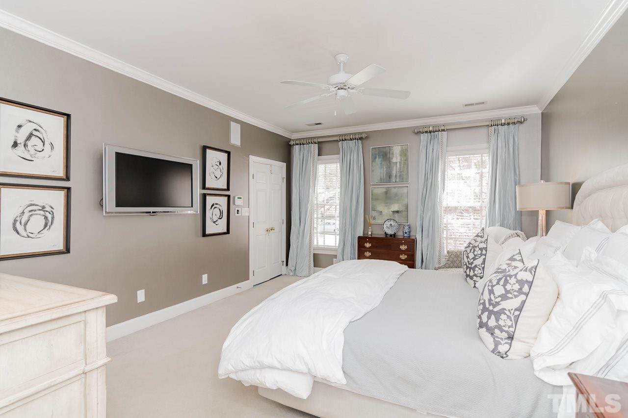 407 Forsyth Street Raleigh, NC 27609 - Photo 17 of 30 a bedroom with a large bed and a flat tv screen on dresser