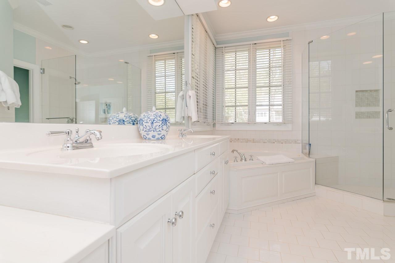 407 Forsyth Street Raleigh, NC 27609 - Photo 19 of 30 a bathroom with double vanity sinks a large mirror and a bathtub