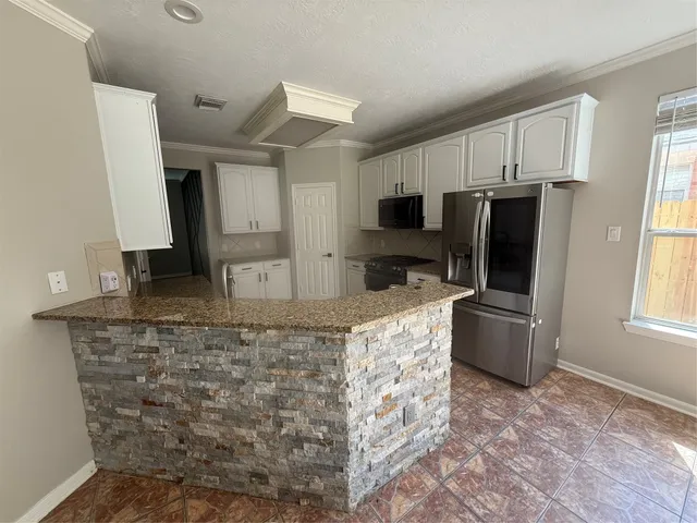 a kitchen with stainless steel appliances granite countertop a refrigerator stove microwave and sink