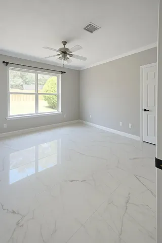 en empty room with windows and chandelier fan