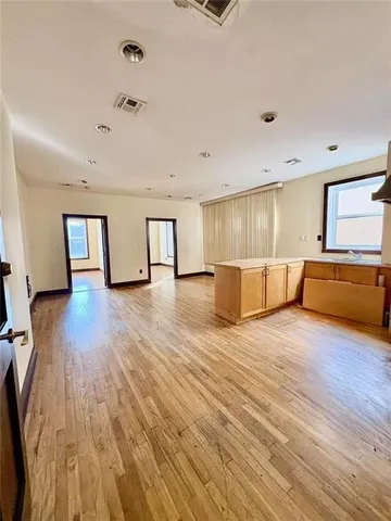 a view of empty room with wooden floor