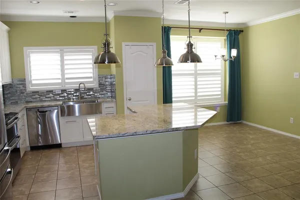 a kitchen with kitchen island granite countertop a sink and a stove