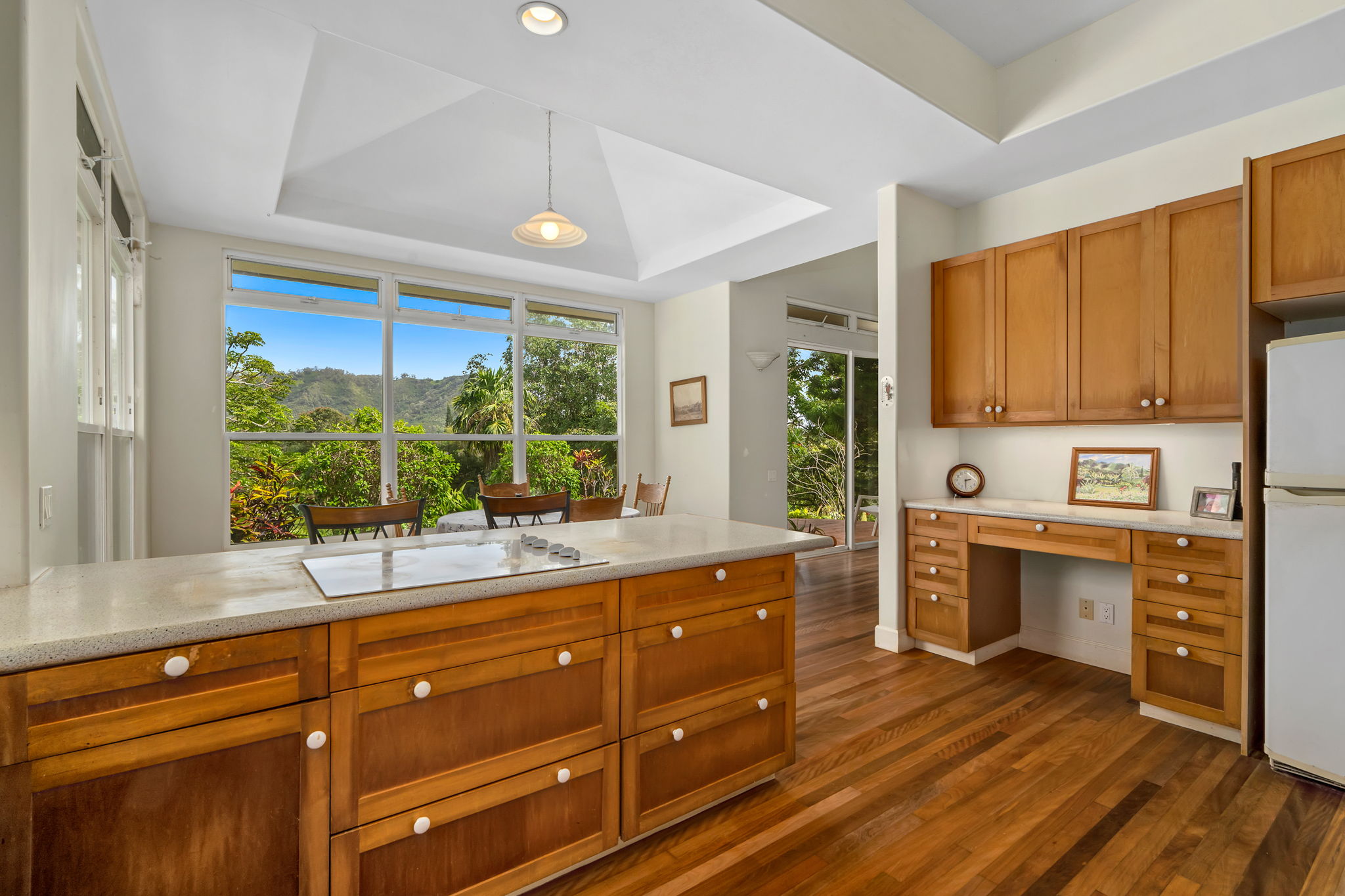 597 Puuopae Road Kapaa, HI 96746 - Photo 12 of 30 a kitchen with wooden floors and white cabinets