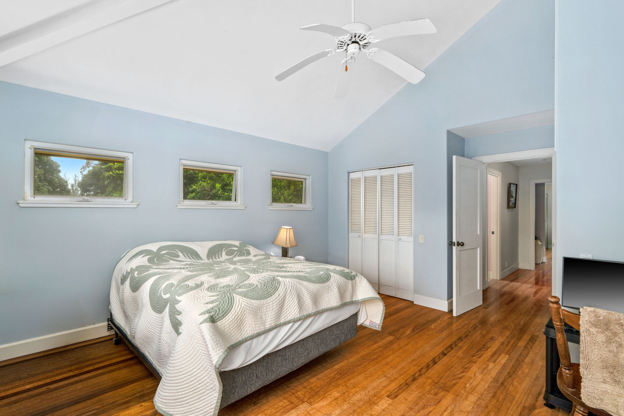 597 Puuopae Road Kapaa, HI 96746 - Photo 21 of 30 a spacious bedroom with a bed and a chandelier