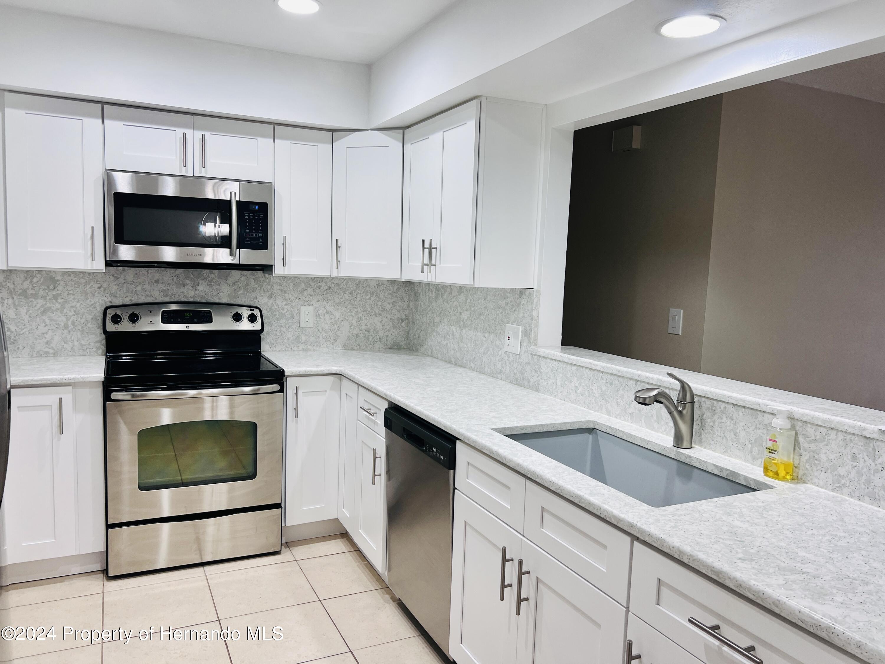 8141 Bugle Court Port Richey, FL 34668 - Photo 11 of 25 a kitchen with a sink and a stove top oven