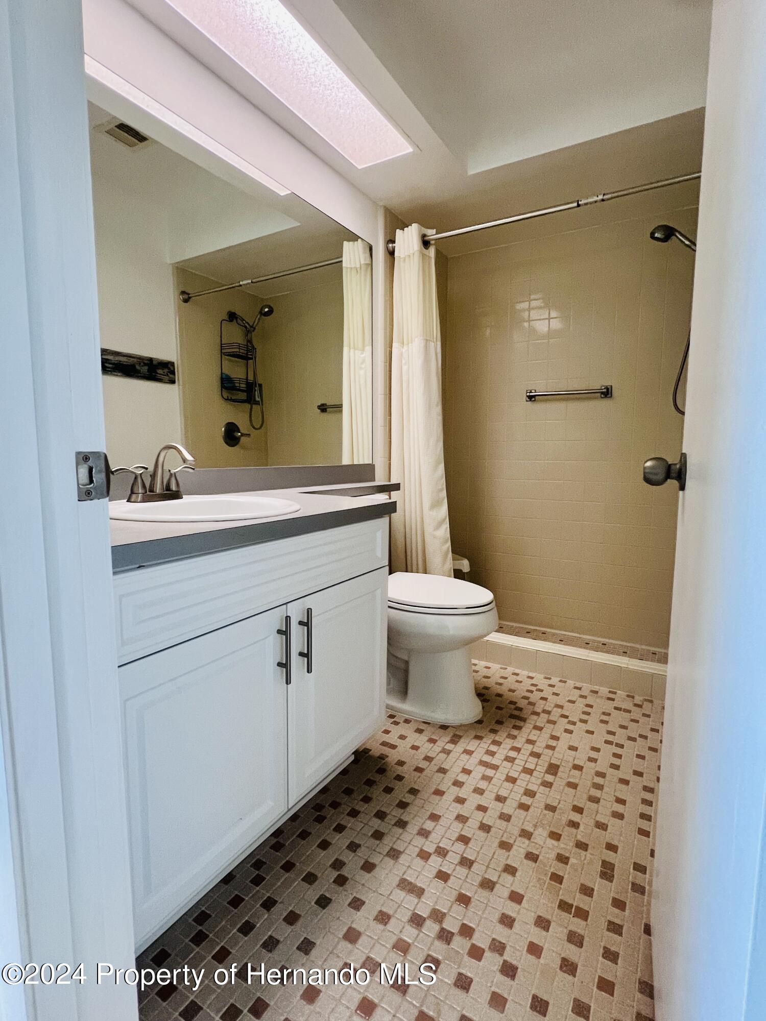 8141 Bugle Court Port Richey, FL 34668 - Photo 17 of 25 a bathroom with a sink toilet a mirror and shower