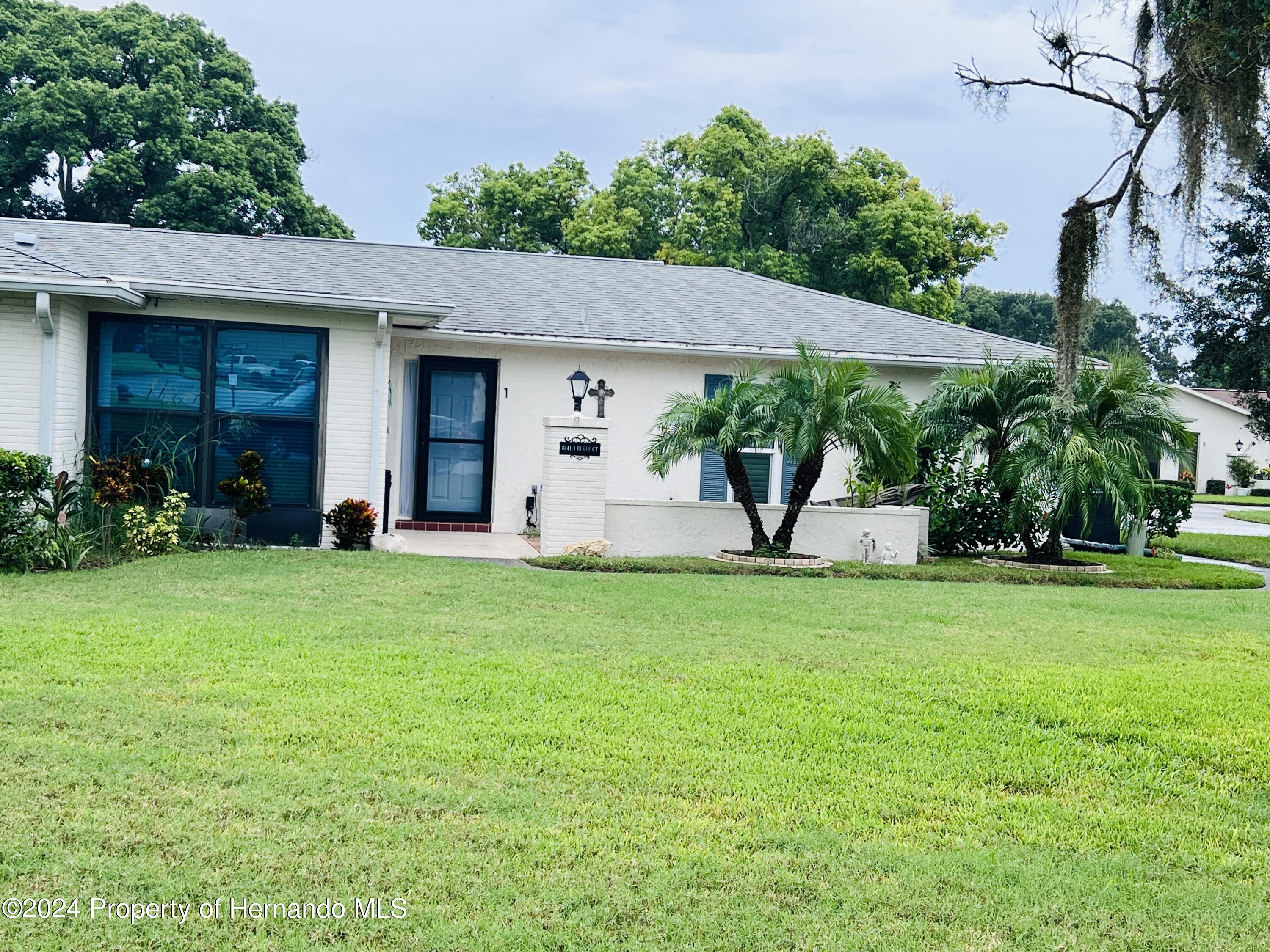 8141 Bugle Court Port Richey, FL 34668 - Photo 2 of 25 a front view of a house with garden