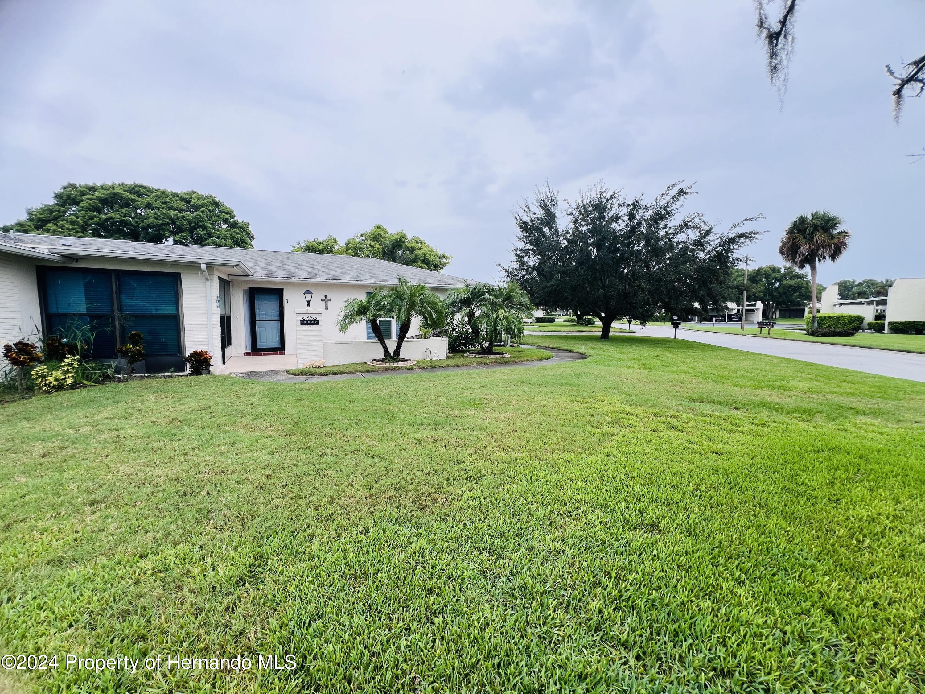 8141 Bugle Court Port Richey, FL 34668 - Photo 23 of 25 a front view of house with yard and green space