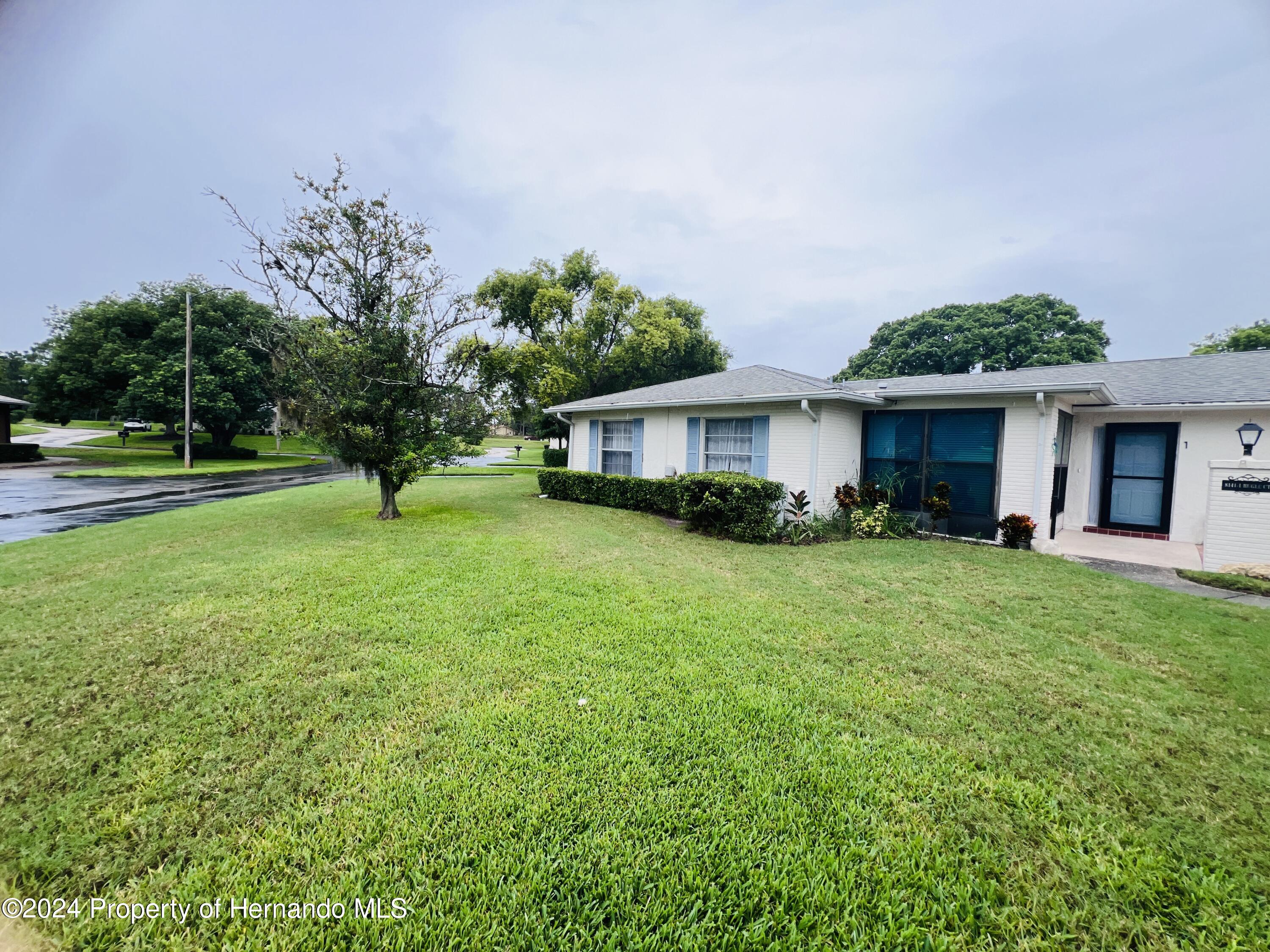 8141 Bugle Court Port Richey, FL 34668 - Photo 24 of 25 a front view of a house with garden