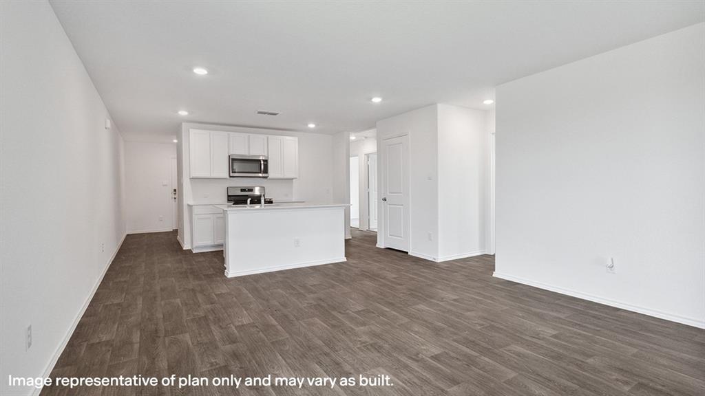 3522 Spring Time Street Forney, TX 75126 - Photo 10 of 27 Open-concept living area featuring wood-finish flooring, recessed lighting, and a kitchen with white cabinetry, stainless steel appliances, and a central island with a sink