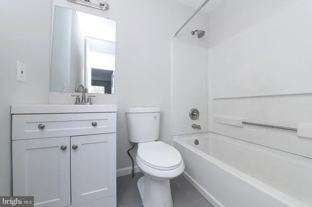 a bathroom with a toilet a sink a mirror and bathtub