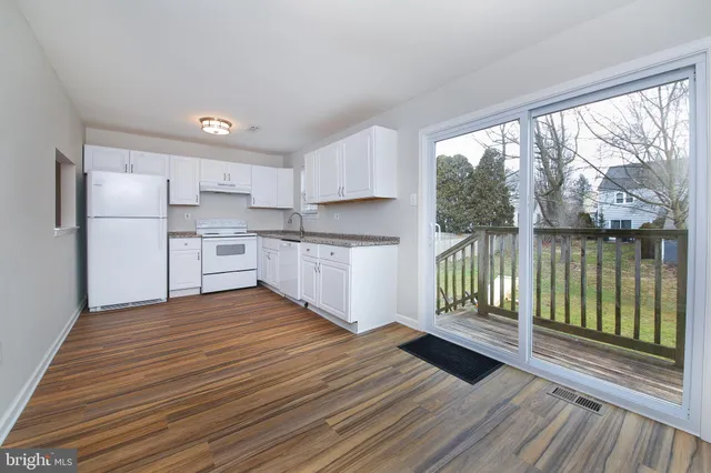 a kitchen with wooden floors and wide window