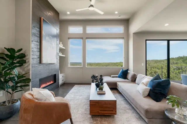 a living room with furniture fireplace and a large window