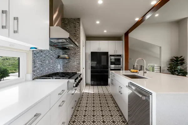 a kitchen with a sink a stove and cabinets