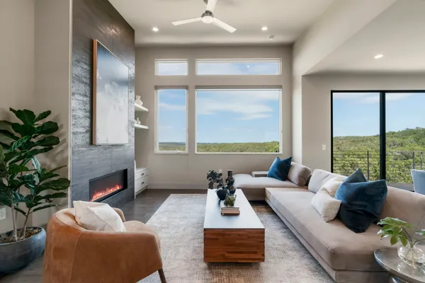 a living room with furniture fireplace and a large window