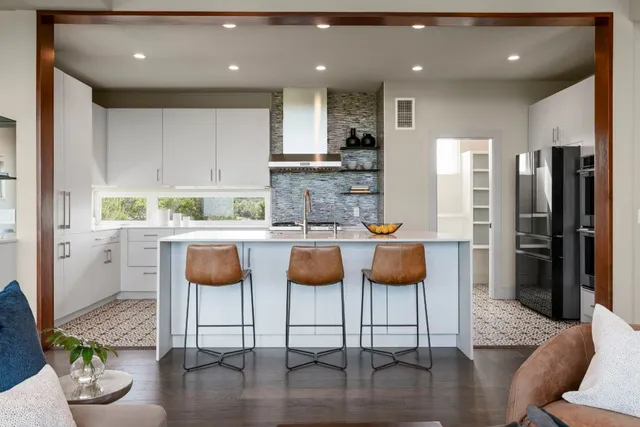 a kitchen with stainless steel appliances granite countertop a refrigerator and a stove top oven