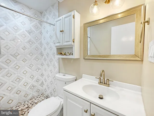 a bathroom with a sink toilet and a mirror