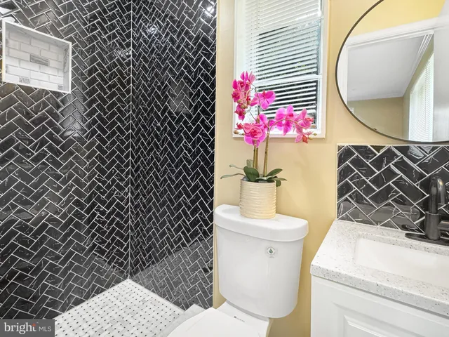 a view of a hallway with a livingroom and a bathroom