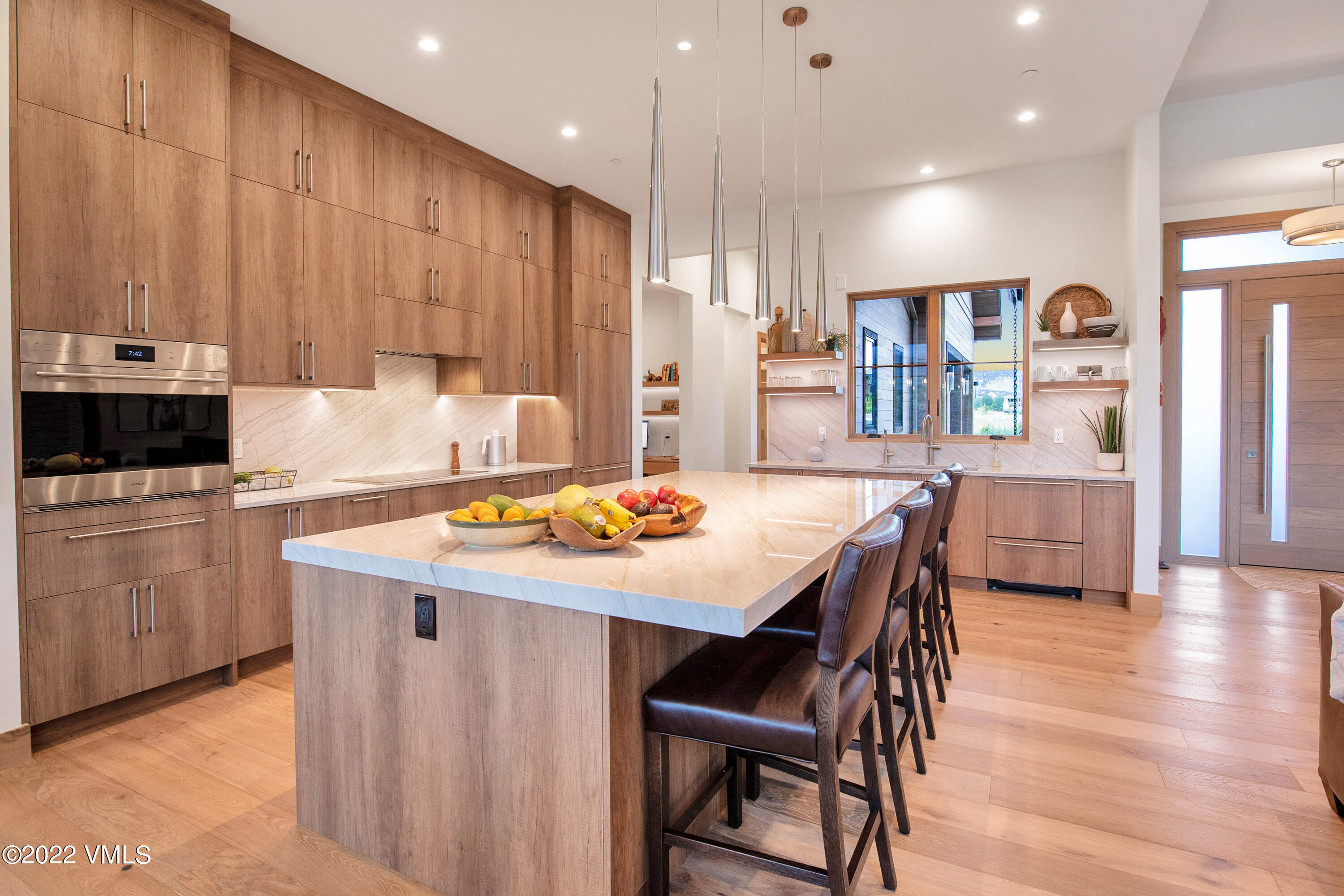 2185 East Haystacker Drive Eagle, CO 81631 - Photo 4 of 30 a kitchen with stainless steel appliances kitchen island granite countertop a table chairs sink and cabinets