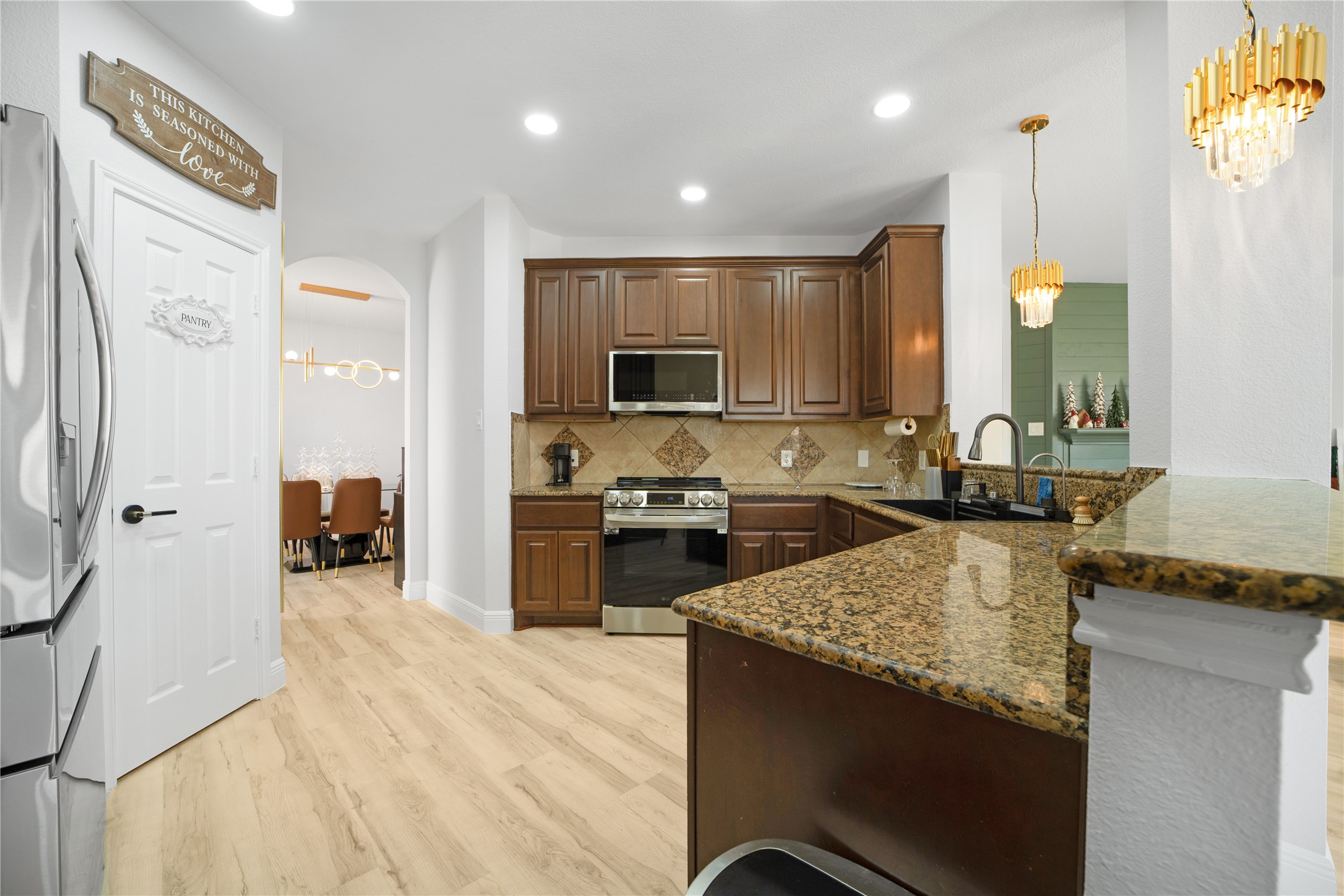 3032 Prairie Bluff Seguin, TX 78155 - Photo 21 of 23 Kitchen with a peninsula, dark stone counters, stainless steel appliances, arched walkways, and light wood-type flooring