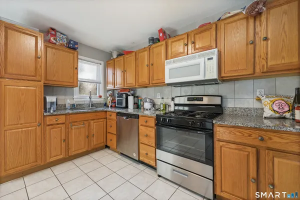 a kitchen with granite countertop white cabinets and stainless steel appliances