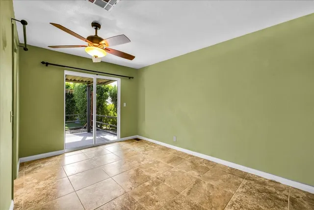 an empty room with closet and a chandelier fan