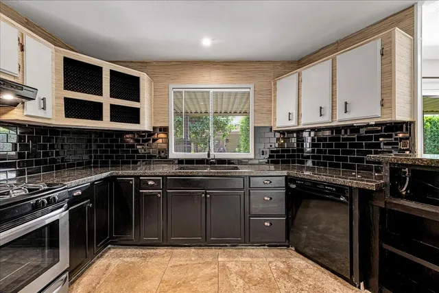 a kitchen with stainless steel appliances granite countertop a refrigerator and a stove